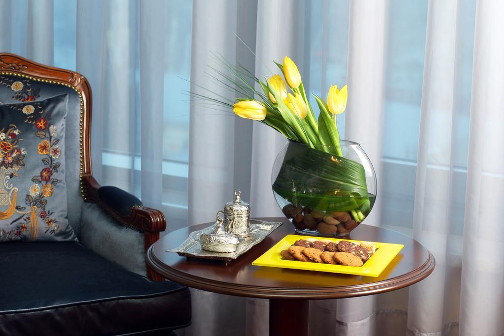 Orion Hotel Biskek Kültér fotó A table with a vase of flowers
